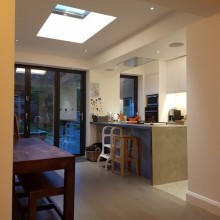 Zinc clad extension to existing terraced house with green flat roof and flat roof lights